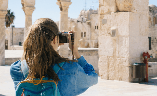 Woman Taking Pictures of Ruins